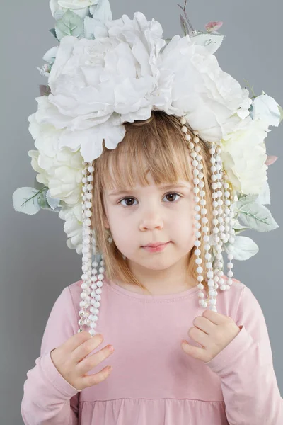 Mała Dziewczynka Nosi Biały Kwiat Kapelusz Patrząc Aparat Szarym Tle — Zdjęcie stockowe