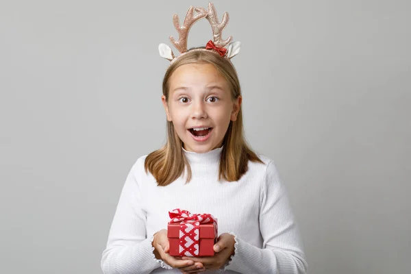 白い背景に赤いXmasプレゼントプレゼントを保持しているハッピークリスマスの少女 — ストック写真