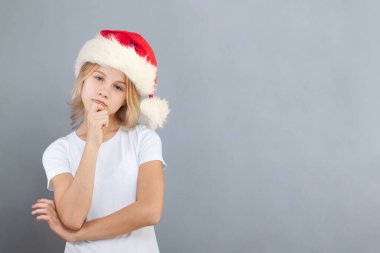 Genç kız Noel Baba açık mavi arka planı düşünüyor.