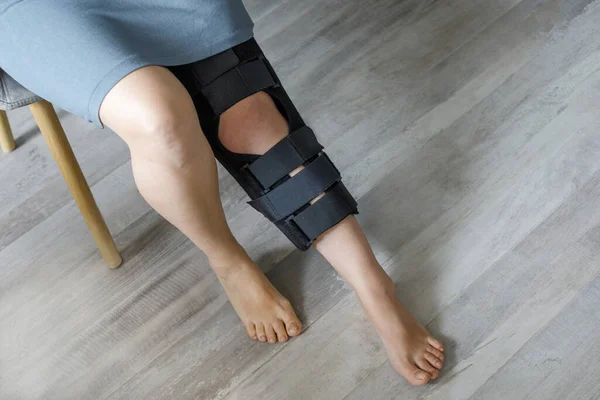 Female leg wearing knee brace closeup. Orthopedic Anatomic Orthosis. Braces for knee fixation, injuries and pain. Foot orthosis tutor