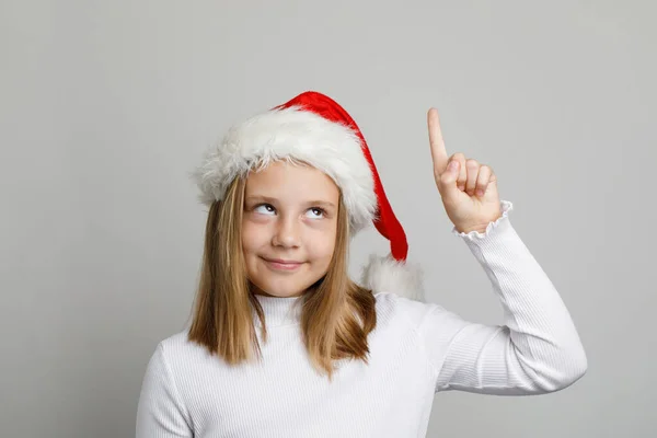 Retrato Natal Menina Engraçada Chapéu Santa Apontando Para Cima Fundo — Fotografia de Stock