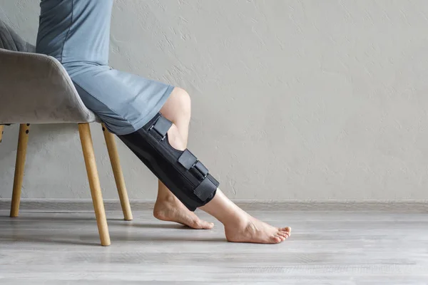 Women leg with knee brace at home