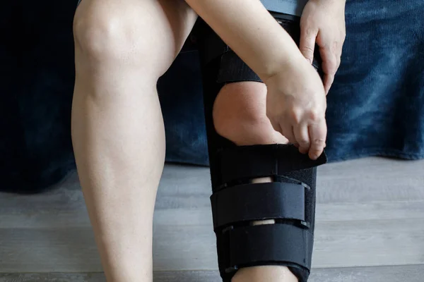 Female leg wearing knee brace. Rehabilitation for knee injury