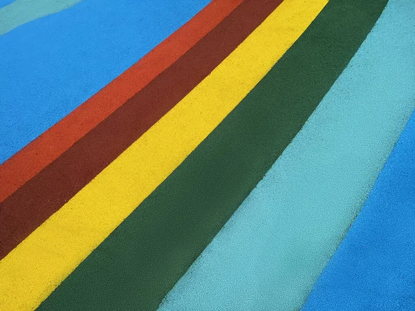 Texture of color rubber floor on playground. Safety Surfacing. Blue, red, green and yellow rubber crumb surface texture backgroun