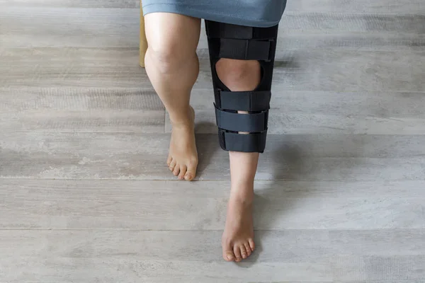 Patient with black knee brace at home