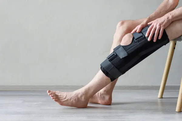 Closeup of knee brace to patient leg on background with copy space