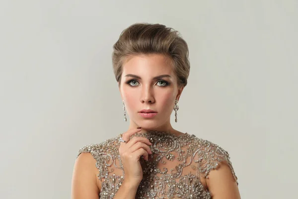 Elegant beautiful woman jewelry model wearing diamond earring on white, fashion beauty portrait