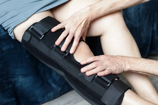 Rehabilitation concept. Man therapist and knee brace in physiotherapy with woman patient, knee pain or consulting expert. Physiotherapist, physical therapy and healthcare worker help, support or advice