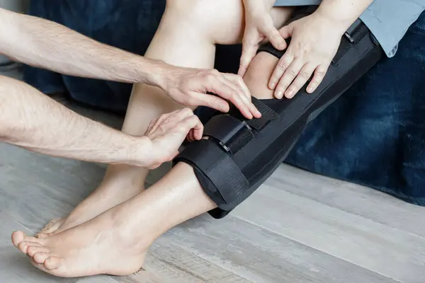 Physiotherapist Fixing Knee Braces on Woman\'s Leg indoor