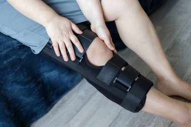 Ortopedist evde kadın dizliği takıyor.