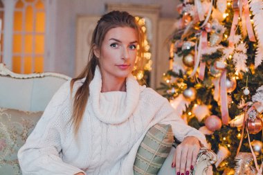 Evde Xmas dekorasyonlu güzel bir kadının portresi. Noel ve Yeni Yıl tatili konsepti.