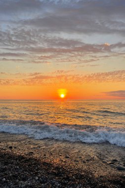 Gün batımı ve deniz. Akşamları mavi bulutlu gökyüzü, sarı güneş ışığı getiriyor. 