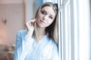 İçerideki kameraya bakan güzel, neşeli kadın modelin portresi.