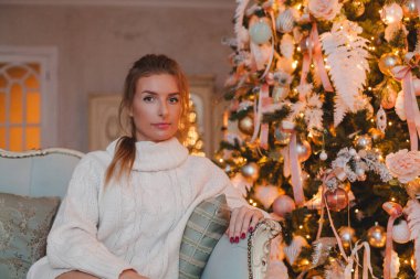 Noel kadını kanepede oturuyor, evde dinleniyor. Noel ve Yeni Yıl tatili konsepti.