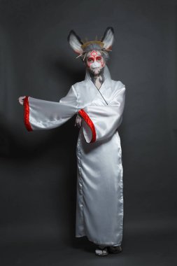 Maske ve kimono kostümlü, sahne makyajlı dansçı kadın oyuncu. Cadılar Bayramı, karnaval, gösteri ve tiyatro konsepti