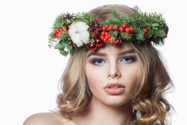 Uzun dalgalı saçları, makyajı ve renkli kış dekorasyonuyla beyaz stüdyo arka planında izole edilmiş mükemmel model kadın, moda güzellik portresi.