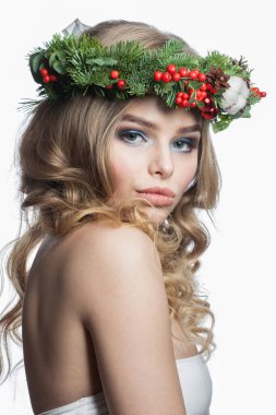 Uzun dalgalı saçları, makyajı ve renkli kış dekorasyonuyla beyaz stüdyo arka planında izole edilmiş duygusal model kadın, moda güzellik portresi.