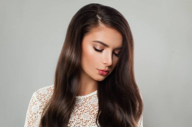 Hoş bir kadın esmer, uzun, sağlıklı koyu kahverengi saçlı, beyaz tenli ve makyajlı. Güzellik tasviri, saç bakım konsepti