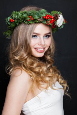 Gülümseyen güzel bir kadın. Beyaz arka planda uzun dalgalı sarı saçlı güzel bir bayan model, moda güzellik stüdyosu portresi