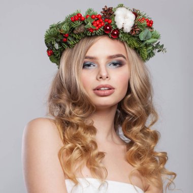 Çekici genç bir kadın kameraya bakıyor, moda güzellik stüdyosu portresi. Beyaz arka planda uzun dalgalı sarı saç modelli güzel bir bayan model.