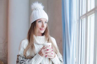 Mükemmel bir kış kadını elinde sıcak kurutma ve evde dinlenme, romantik bir portre