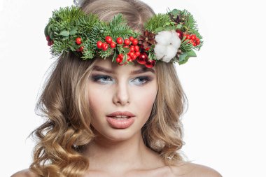 Parti makyajı, uzun sarı kıvırcık saç modeli ve beyaz arka planda izole edilmiş Noel dekoru olan mükemmel sağlıklı genç bir kadın. Noel güzeli