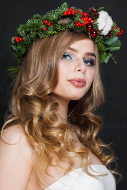 Noel güzeli kadın. Makyajlı güzel bir manken, temiz bir ten, dalgalı sarı saç ve yılbaşı süsü.