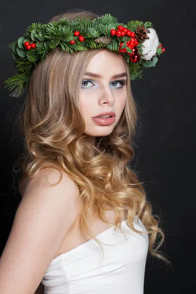 Christmas beauty woman. Glamorous model with makeup, clean fresh skin, wavy blonde hair and Xmas New Year decoration