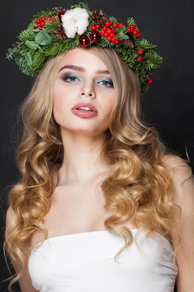 Christmas beauty woman. Beautiful fashion model with makeup, clean fresh skin, wavy blonde hair and Xmas New Year decoration