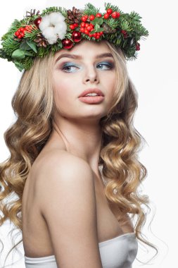 Parti makyajı, uzun sarı kıvırcık saç modeli ve beyaz arka planda izole edilmiş Noel dekoru olan çekici, sağlıklı genç bir kadın. Noel güzeli