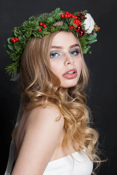 Christmas beauty woman. Gorgeous model with makeup, clean fresh skin, wavy blonde hair, perfect smile and Xmas New Year decoration