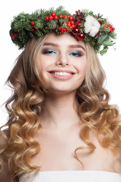 Christmas beauty woman. Cheerful young model with makeup, clean fresh skin, wavy blonde hair, perfect smile and Xmas New Year decoration