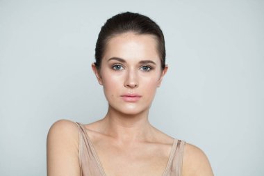 Çekici moda mankeni esmer, açık tenli ve koyu saçlı. Güzel, genç bir kadın yüzü. Yakın plan portresi.