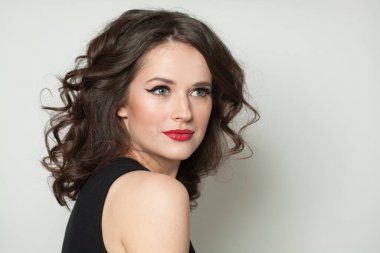 Güzel kadın esmer, makyajlı ve parlak dalgalı kahverengi saçlı stüdyo resmi var. Moda, makyaj, saç stili, kişisel bakım, güzellik salonu, kozmetik ve moda konsepti