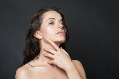 Hoş bir kadın kusursuz, pırıl pırıl, taze yüz derisine dokunuyor, portresi. Sağlık, sağlık, güzellik tedavisi ve kozmetoloji kavramı