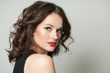Güzel bir esmer kadın, makyajlı ve parlak dalgalı kahverengi saçlı stüdyo resmi var. Moda, makyaj, saç stili, kişisel bakım, güzellik salonu, kozmetik ve moda konsepti