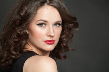 Güzel kadın esmer, makyajlı ve parlak dalgalı kahverengi saçlı stüdyo resmi var. Moda, makyaj, saç stili, kişisel bakım, güzellik salonu, kozmetik ve moda konsepti