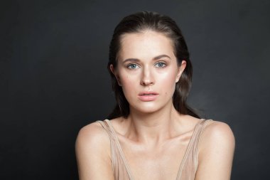 Sağlıklı, ıslak ciltli, koyu renk saçlı, kameraya bakan mükemmel bir kadın modeli. Moda güzelliği portresi.