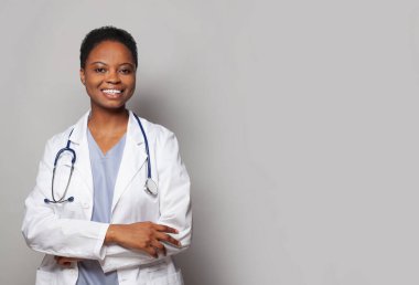 Beyaz arka planda laboratuvar önlüklü, kendinden emin, mutlu doktor kadın sağlık görevlisi.