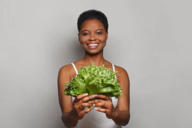 Beyaz arka planda sebze yeşili marul tutan neşeli bir kadın. Sağlıklı yaşam tarzı, Vegan, Diyet ve Diyet Konsepti