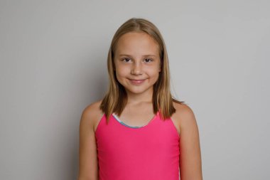 Pembe mayo giymiş neşeli bir kız çocuğu. Seyahat, spor, yüzme aktiviteleri ve tatil konsepti