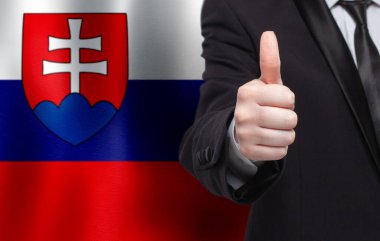 Slovakça bir kavram. Slovakya bayrağının arka planında başparmağını gösteren iş adamı