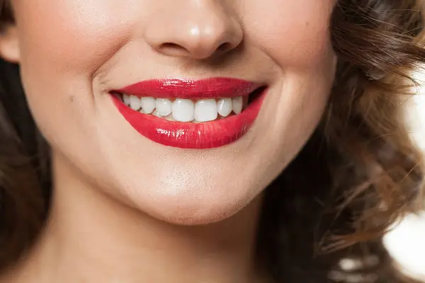 Beautiful female smile with white teeth and red lips closeup beauty portrait