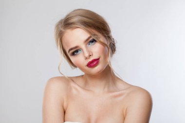 Beyaz arka planda izole edilmiş mükemmel sağlıklı sarışın model. Makyajlı, temiz tenli ve dalgalı sarı saçlı bir kadın. 