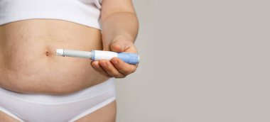 Kadın model Semaglutide enjeksiyon kalemini ya da insülin kartuş kalemini açtı. Kilo kaybı ve diyabet konsepti. 