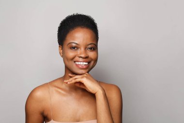 Neşeli kadın model yüzü. Sağlıklı, taze tenli, tatlı gülüşlü, stüdyo portresi olan güzel bir kadın. Yüz tedavisi, sağlık ve kozmetoloji kavramı