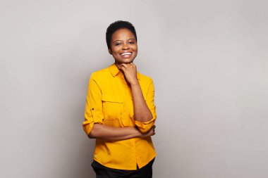 Çekici mutlu kadın gülümsüyor ve beyaz stüdyo duvarına karşı eğleniyor. Duygusal ifade portresi.