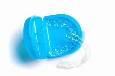 Beyaz arka planda mavi kutulu dişlerin beyazlatılması ve düzleştirilmesi için görünmeyen hizalayıcıların üst görüntüsü. Parantez üstüne ortodontik terapi. Diş Sağlığı Hizmetleri