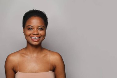 Temiz bir kadın model yüzü. Sağlıklı, taze tenli, tatlı gülüşlü, stüdyo portresi olan güzel bir kadın. Yüz tedavisi, sağlık ve kozmetoloji kavramı