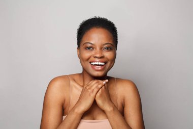 Neşeli kadın model yüz. Sağlıklı, taze tenli, tatlı gülüşlü, stüdyo portresi olan güzel bir kadın. Yüz tedavisi, sağlık ve kozmetoloji kavramı